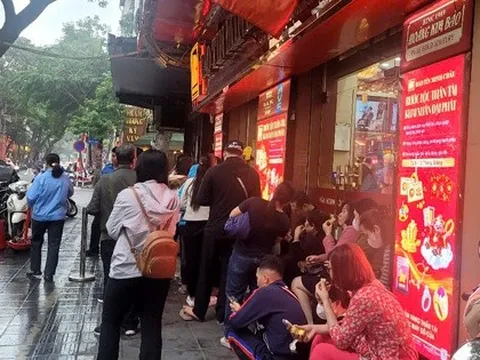 Người dân đội mưa xếp hàng chờ mua vàng trước ngày vía Thần Tài